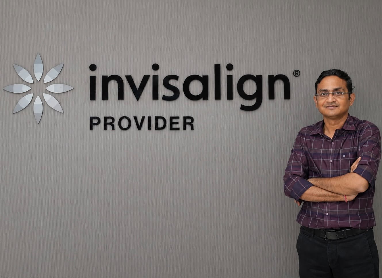 Dr. Naresh Khandelwal beside Invisalign Provider signage